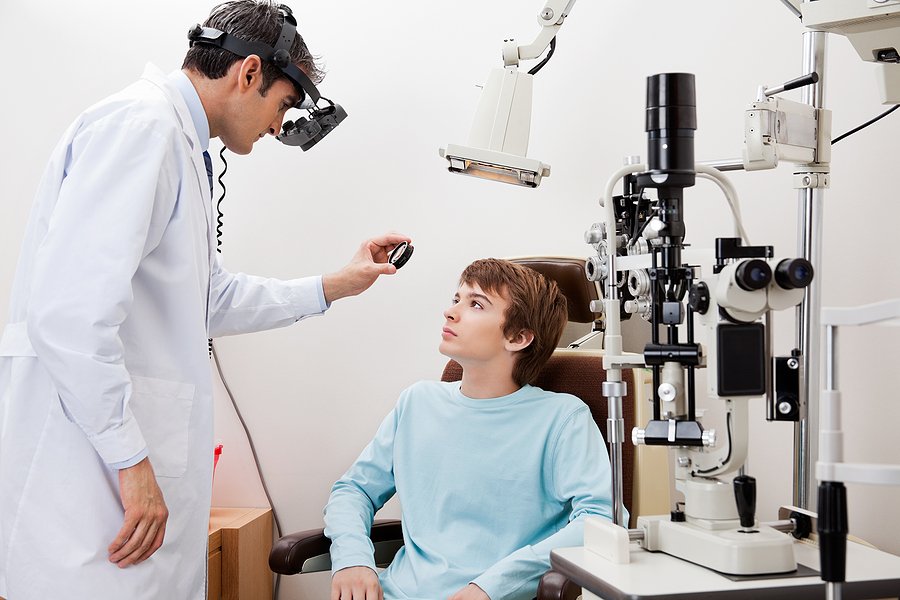 Young boy going through dilated retinal exam done by optometrist How Lifestyle Changes Can Impact Macular Disease Progression